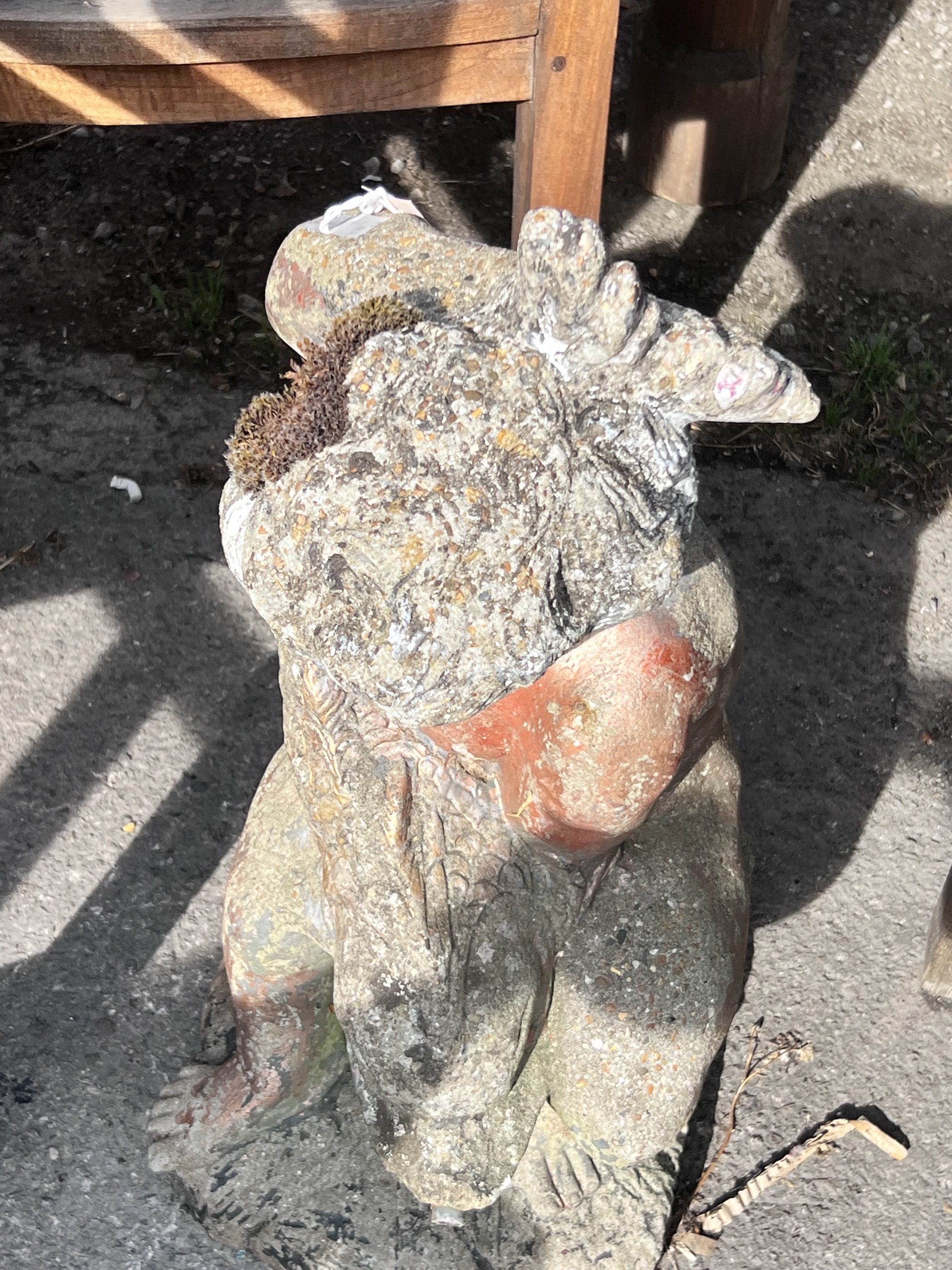 A reconstituted stone garden fountain modelled as a figure of a cherub holding a dolphin, height 69cm